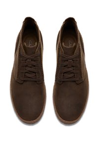 Hnědé kožené boty s hladkým povrchem, šněrováním a minimálním prošíváním. Podešev je mírně texturovaná pro lepší přilnavost.