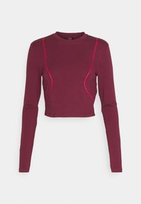 Top cropped a manica lunga color bordeaux con dettagli in cuciture rosa. Presenta un colletto rotondo e un design aderente per un aspetto snello.