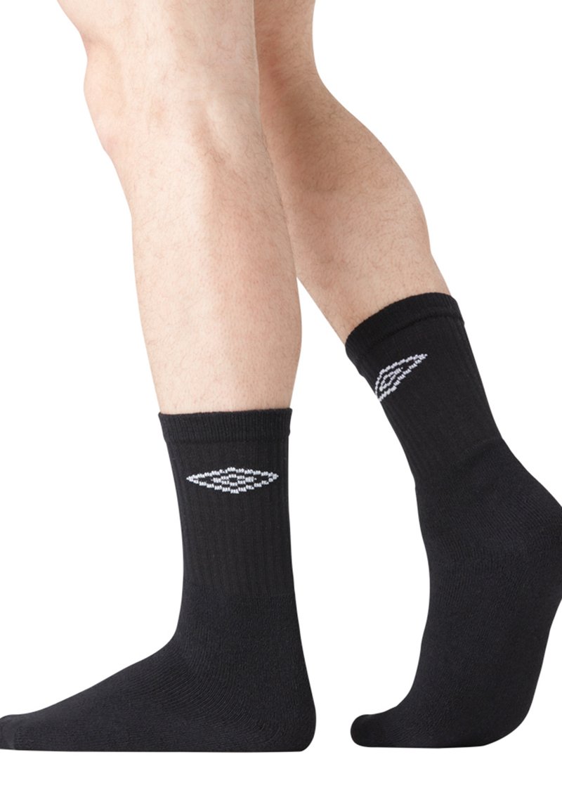 Chaussettes de cheville en coton noir avec une texture côtelée, présentant un logo en motif diamant gris de chaque côté. Tissu doux et coupe confortable.