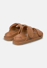 Sandali di pelle marrone con cinturini intrecciati, soletta imbottita e suola texturizzata. Il design presenta una forma arrotondata e cuciture a contrasto.
