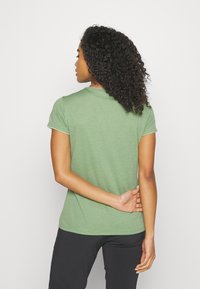 Πράσινο κοντομάνικο μπλουζάκι φτιαγμένο από μαλακό ύφασμα, με στρογγυλή λαιμόκοψη και ίσια τελείωμα. Η υφή φαίνεται λεία με ελαφριά γυαλάδα.