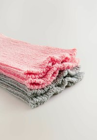 Tre par af strikkede sokker: et lys pink, et mørkere pink og et gråt, hver med et struktureret rib mønster og krøllet kant.