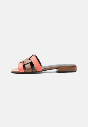 Ravni natikač s širokimi koralnimi in rjavimi usnjenimi trakovi ter nizkim kvadratnim petom na belem ozadju.