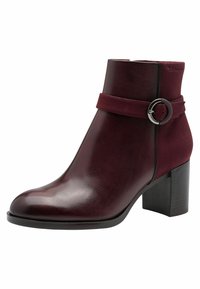 Bottine bourgogne en cuir lisse, avec une bande en daim et une boucle circulaire, et un talon épais. Design élégant avec un bout arrondi.