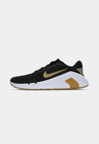 Sort atletiksko med en mesh-overdel, guldfarvede detaljer på Swoosh-logoet og en hvid mellemsål med en gummigummisål.