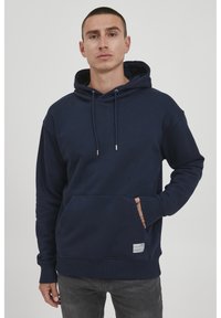 Marineblaues Kapuzensweatshirt aus weichem Stoff, mit einer Fronttasche, Kordelzügen und gerippten Bündchen und Saum. Schlichtes Design.