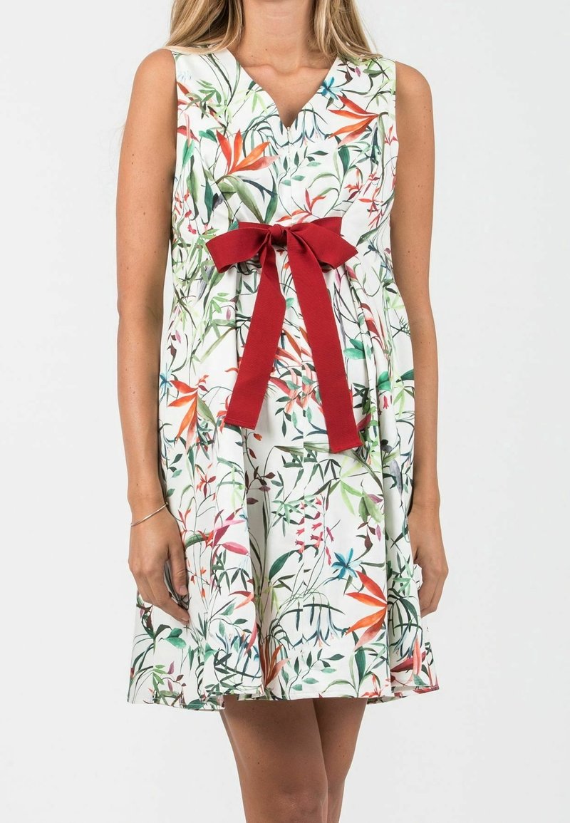 Floral dress with a v-neck, sleeveless design. Features a white fabric with green, red, and blue plant patterns and a red bow at the waist.
