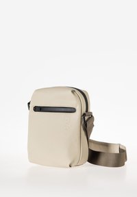 Borsa a tracolla beige chiaro realizzata in materiale morbido, con una finitura liscia, una tasca con zip frontale e una tracolla regolabile marrone.