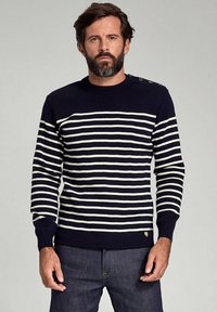 Marineblau gestreifter Pullover mit weißen horizontalen Linien, rundem Hals und Knopfdetails an der Schulter. Rippbündchen und -saum. Baumwollmischung.