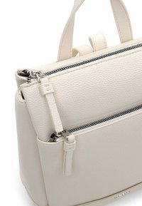 Struktureeritud kreemjas nahast käekott kahe tõmblukuga, tekstuurse pinnaga, lühikeste ülaosakäepidemetega ning minimalistlike disainielementidega.