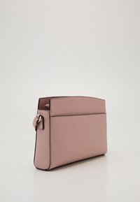 Różowa skórzana torebka o teksturowanym wykończeniu, prostokątnym kształcie, kontrastowych czarnych krawędziach oraz bocznym pasku z metalowym zapięciem.