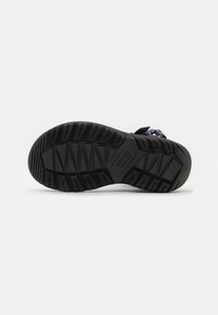 Soletta in gomma nera con un motivo di tread strutturato e branding. Presenta cinturini regolabili con accenti multicolori e una costruzione robusta.