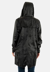 Zwarte, hoodie-jas gemaakt van glad, textuurstof. Heeft een rugventilatie en een ontspannen pasvorm die onder de heupen eindigt.