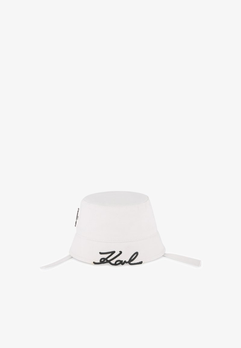 Witte bucket hat van canvas met een ronde bovenkant en brede rand, voorzien van zwarte borduursel "Karl" aan de voorkant en verstelbare bandjes.