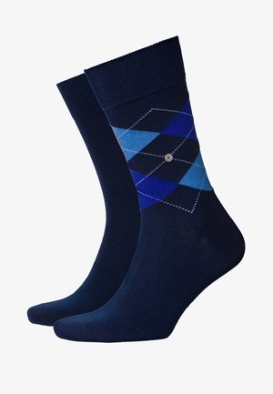 Chaussettes bleu marine avec un motif en losanges dans des nuances de bleu, présentant un petit emblème et un poignet côtelé pour une texture supplémentaire.