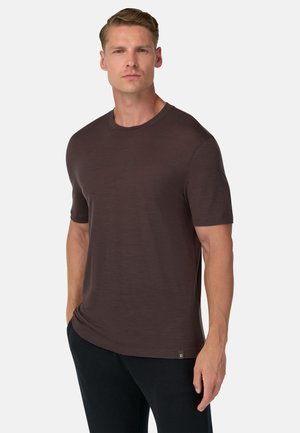 Brązowy t-shirt z krótkim rękawem i okrągłym dekoltem, wykonany z miękkiego materiału. Lekko dopasowany krój z dyskretną metką blisko dolnej krawędzi.