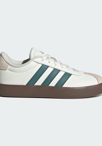 Biele tenisky s tromi tyrkysovými pruhmi, vrchná časť z texturovanej kože a béžový semišový pútko na päte. Hnedá gumová podrážka, okrúhle šnúrky a polstrovaný golier.