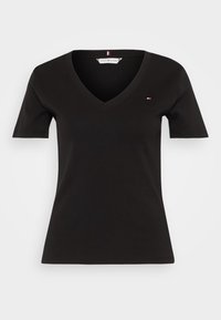 Svart V-ringad T-shirt i bomull, med kort ärm och en liten logotypdetalj på bröstet. Slät yta och figurnära design.