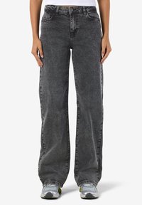 Högmidjade vida jeans i en bleknad svart denim. Har fem fickor, bältesömmar och ett texturerat tyg med subtil blekning.