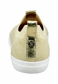 Baskets de couleur champagne avec un dessus en tricot texturé, semelle en caoutchouc blanche et un tirant de talon métallique doré avec un détail de logo.