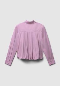Blusa a maniche lunghe di colore lavanda con polsini abbottonati, dettagli plissettati sul retro e un orlo arricciato su uno sfondo semplice.