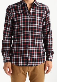 Svart, röd och vit rutad långärmad skjorta med knäppning framtill och spetsig krage, tillverkad av en texturerad bomullstyg.