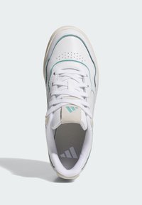 Vit sneaker med turkosa detaljer, perforerad tå, texturerad grå innersula och platta snören. Har texturerat läder och meshmaterial.