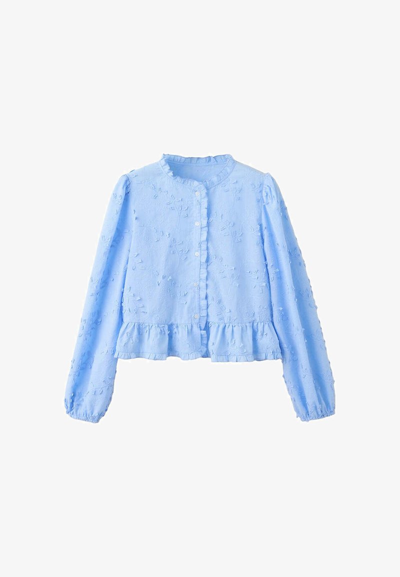 Blouse bleu clair à manches longues avec petits volants sur le col, la patte de boutonnage et l’ourlet, présentant des motifs floraux texturés.