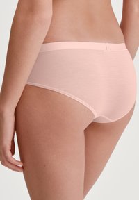 Lichtroze katoenen slip met een gladde textuur, medium hoge taille en minimale stikseldetails. Voorzien van een comfortabele elastische tailleband.