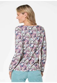 Langarmshirt mit einem bunten Blumen- und Wellenmuster, aus leichtem Stoff gefertigt. Das Design hat einen runden Halsausschnitt und eng anliegende Ärmel.