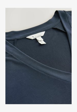 Maglietta a maniche corte blu navy con scollo a V, realizzata in cotone morbido e liscio, dal taglio rilassato. Cuciture visibili e un'etichetta con dettagli del marchio sul collo.