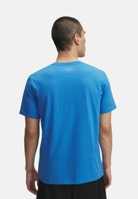 Sinine puuvillane T-särk lühikeste varrukatega ja ümarate kaelustega. Omab väikest logo ülemisel seljal. Sujuv tekstuur ja mugav lõige.