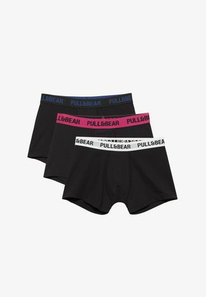 Trzy pary czarnych bokserek z elastycznymi pasami w kolorze białym, różowym i czarnym, każda opatrzona marką z tekstem "PULL&BEAR".