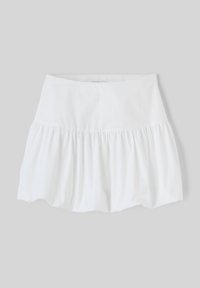 Jupe blanche en tissu léger, avec une taille ajustée et un design à volants froncés à l'ourlet pour un volume supplémentaire.