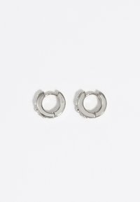 Pendientes de aro plateados con un acabado pulido, que presentan una forma circular y pequeños acentos en un lado. Diseño ligero.