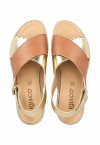 Sandali incrociati marroni e dorati con una tomaia in pelle liscia e una soletta beige imbottita.
