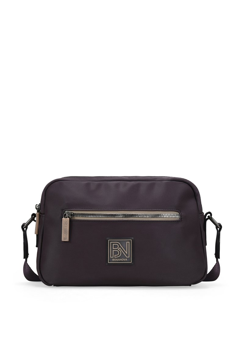 Bolso de hombro de nailon morado con un bolsillo frontal con cremallera, correa ajustable y una placa con el logotipo en tono dorado. Textura suave y diseño minimalista.