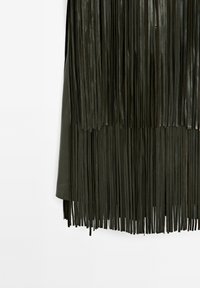 Donkergroene leren rok met lange, dunne verticale franjes die hangen tegen een effen witte achtergrond.