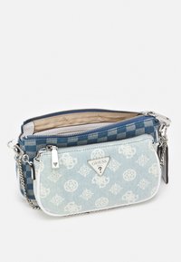 Modrá kostičkovaná látka a světle modrá denimová kabelka přes rameno se stříbrným kováním, obsahující logo, zipové uzavření a řetězový popruh.