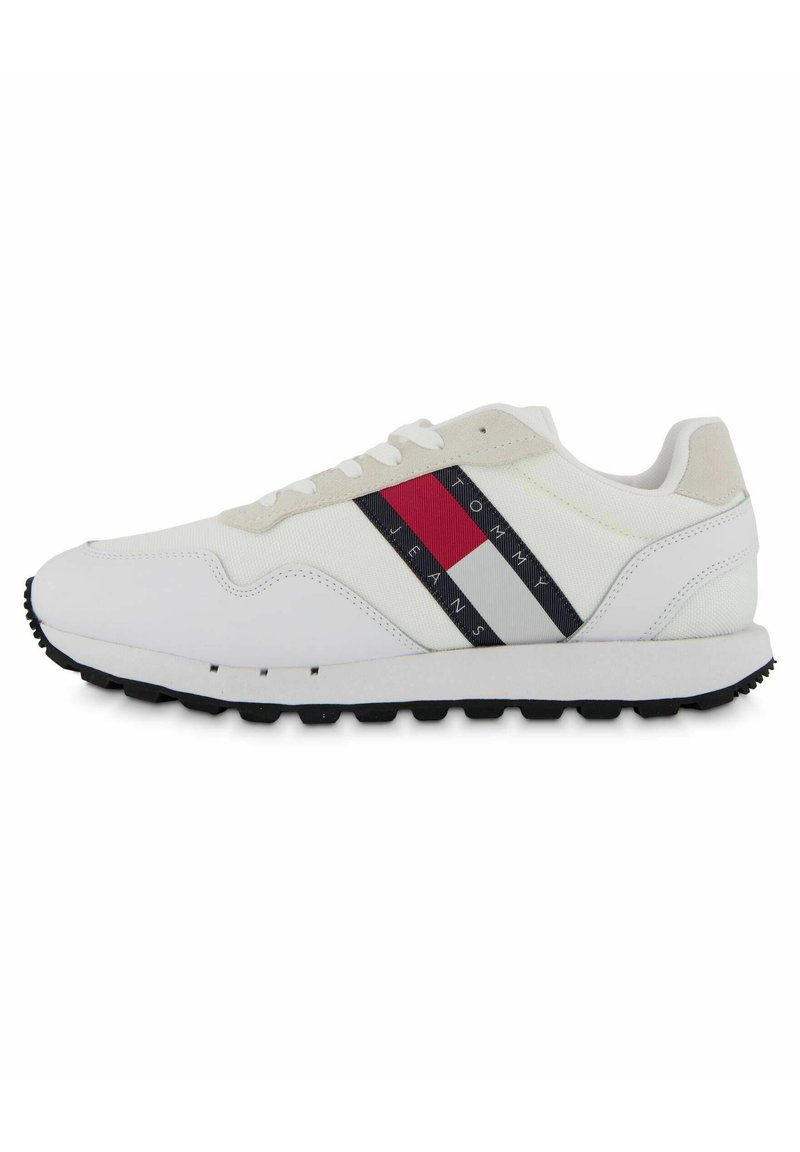 Scarpe sportive bianche con suola in gomma nera, dotate di una tomaia in tessuto testurizzato, un tallone in suede beige e accenti a righe rosse, blu navy e bianche.