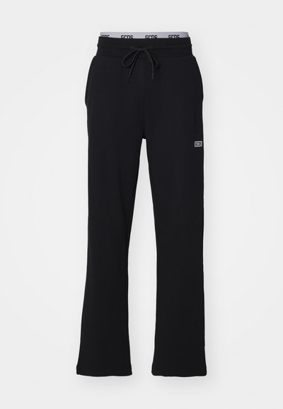 Pantalones deportivos negros de tela suave, con una cintura elástica con cordón y piernas acampanadas. Incluye un pequeño logo en el lateral.