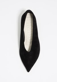 Ballerine nere in suede a punta con un profondo taglio a V nella parte frontale e una soletta liscia color crema con branding in rilievo.