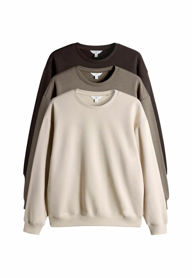 Tres sudaderas de cuello redondo apiladas, de colores beige, topo y marrón oscuro, exhibidas sobre un fondo blanco.