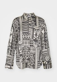 Long-sleeve shirt in black and white with varied geometric and floral patterns. Made of smooth fabric, featuring a buttoned collar and chest pocket.