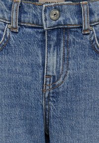 Jean en denim bleu avec fermeture à bouton, conception à cinq poches et coutures orange contrastantes. Le tissu a un aspect texturé avec des décolorations.