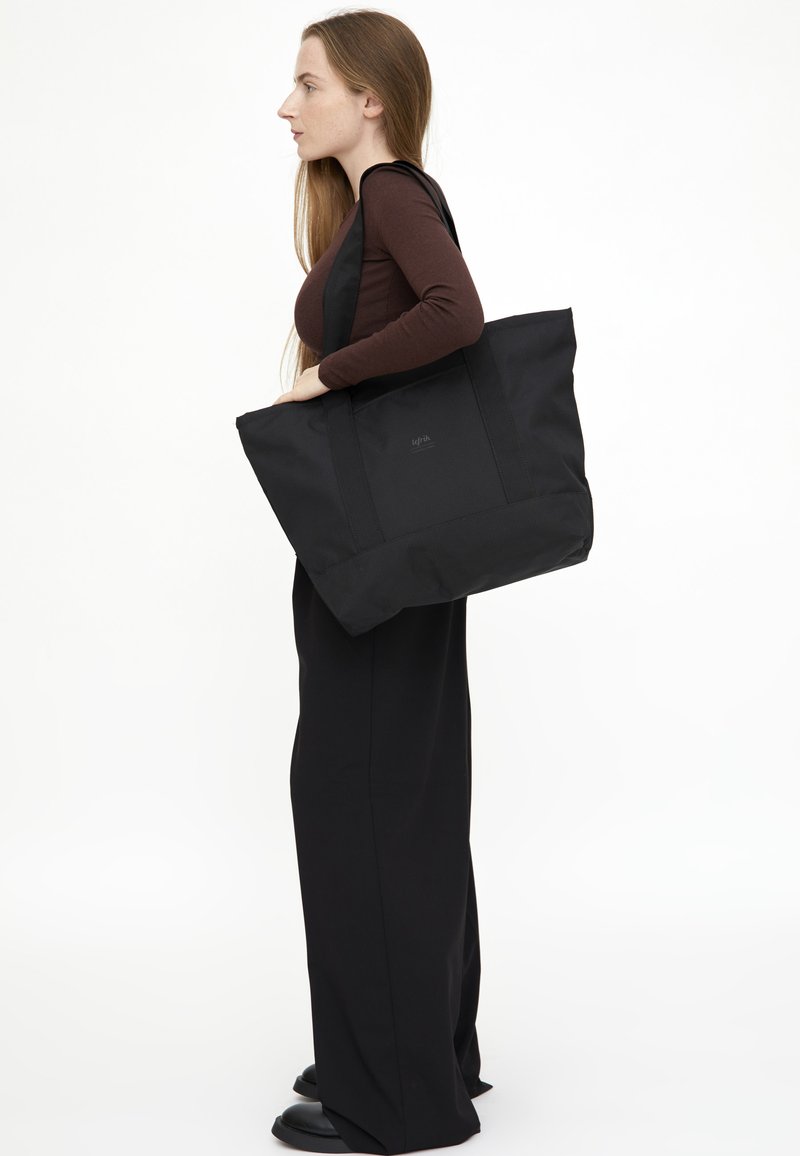 Svart axelväska i hållbart material, med en rymlig design, dubbla axelremmar och minimal logotyp på framsidan.