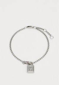 Bracciale in argento con un charm a forma di lucchetto. Presenta una piccola striscia tricolore sulla chiusura. I collegamenti sono lisci e dall'aspetto metallico.