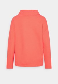 Maglia a maniche lunghe color corallo con un motivo testurizzato, dotata di un colletto ampio e orlo dritto, vista da dietro.