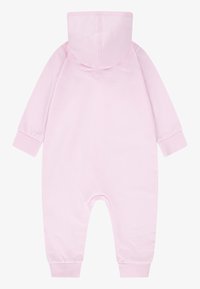 Combinaison en coton rose avec capuche, manches longues et poignets côtelés. Tissu lisse et coupe décontractée, dotée d'un design à siège dégagé pour un accès facile.