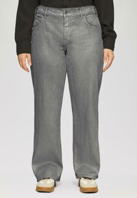 Grijze metallic straight-leg jeans met vijf zakken, sluiting met een voorste knoop en een zachte textuur, gecombineerd met witte en beige sneakers.